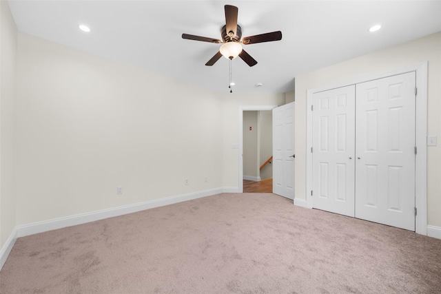 unfurnished bedroom featuring light carpet, ceiling fan, and a closet