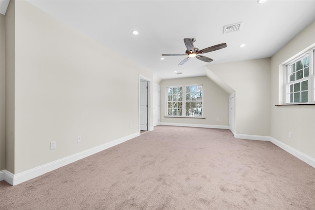 additional living space with ceiling fan and light colored carpet