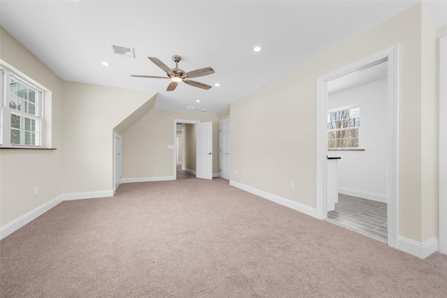 bonus room featuring ceiling fan and light carpet