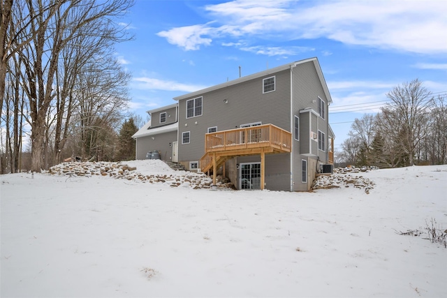 snow covered house featuring a wooden deck