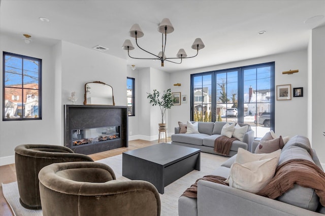 living room with a chandelier and light wood-type flooring