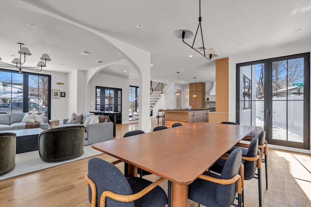 dining space with french doors and light wood-type flooring