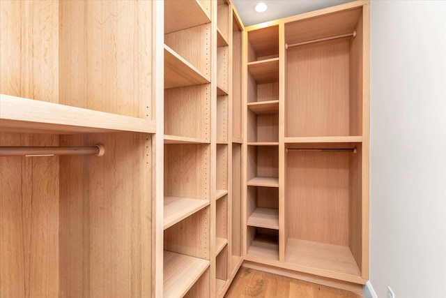 spacious closet with hardwood / wood-style flooring