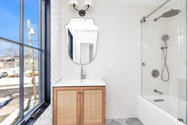 bathroom featuring vanity, tiled shower / bath combo, and a healthy amount of sunlight