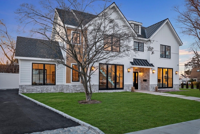 modern farmhouse style home featuring a lawn