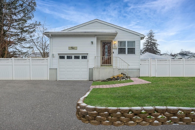 view of front of home with a garage and a front lawn