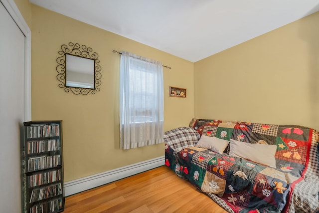 bedroom featuring a baseboard radiator and hardwood / wood-style floors