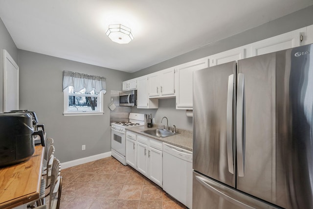 kitchen featuring sink, light tile patterned flooring, white cabinets, and appliances with stainless steel finishes