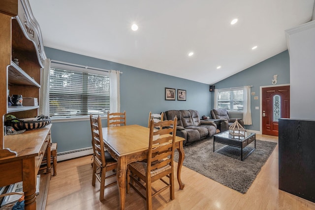 dining area with lofted ceiling, a baseboard radiator, and light wood-type flooring