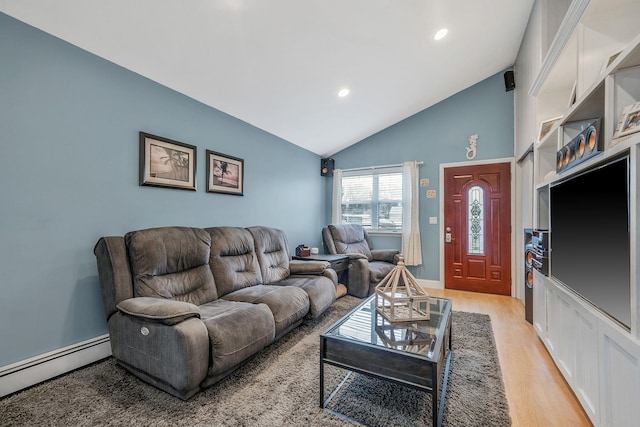 living room featuring lofted ceiling, a baseboard heating unit, and light hardwood / wood-style floors