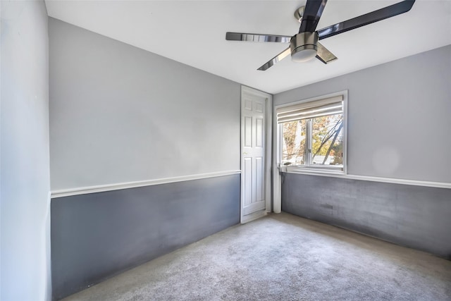 carpeted spare room with ceiling fan