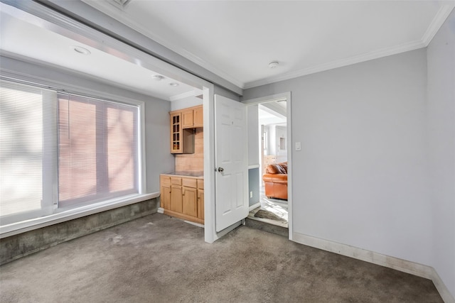 unfurnished living room featuring ornamental molding and dark colored carpet