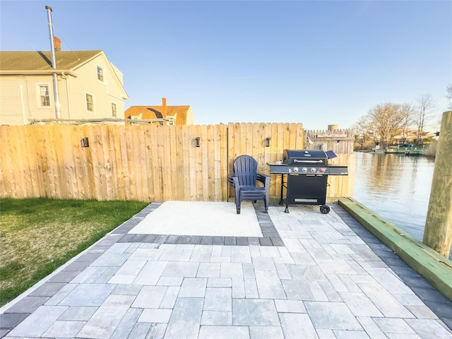 view of patio / terrace featuring grilling area and a water view