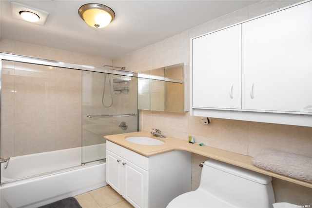 full bathroom featuring tile walls, tasteful backsplash, combined bath / shower with glass door, and toilet