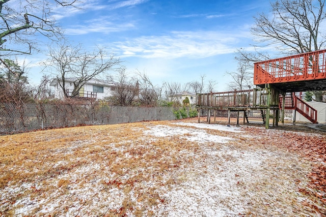 yard covered in snow with a deck