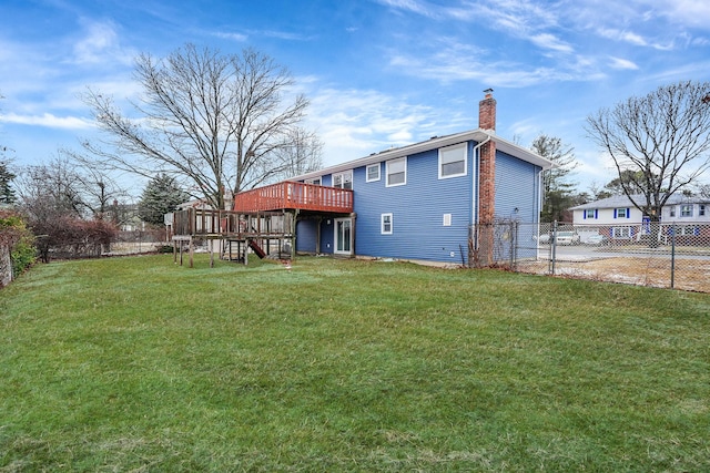 rear view of property featuring a lawn and a deck