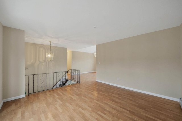 spare room featuring hardwood / wood-style floors and a notable chandelier