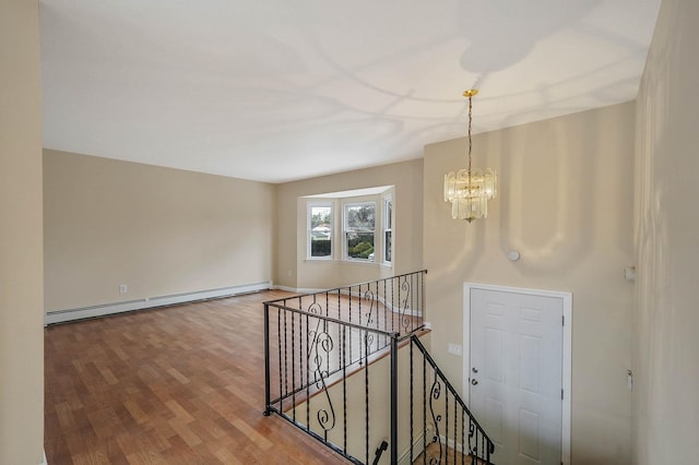 interior space featuring baseboard heating, a chandelier, and hardwood / wood-style flooring