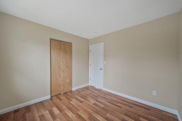 unfurnished bedroom with hardwood / wood-style flooring and a closet