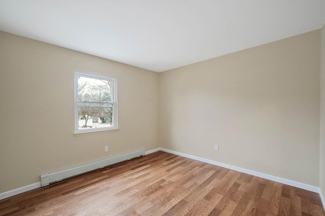 empty room with light wood-type flooring and baseboard heating