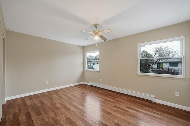 empty room featuring hardwood / wood-style flooring, a baseboard radiator, and ceiling fan