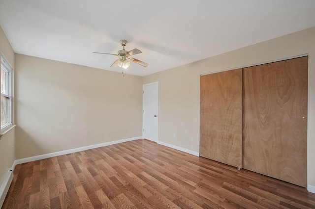 unfurnished bedroom with wood-type flooring, ceiling fan, and a closet