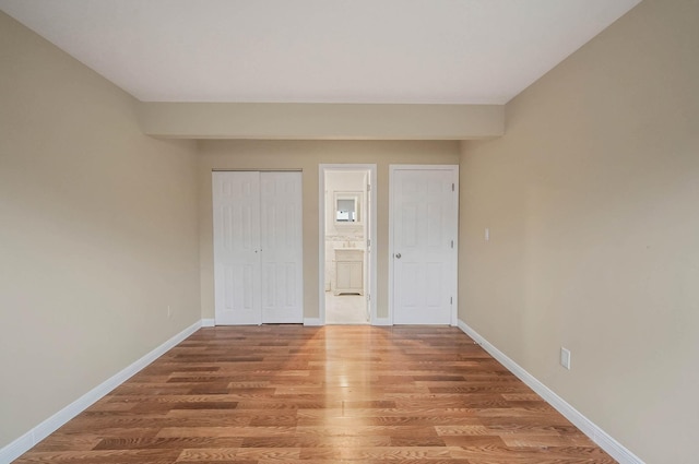 unfurnished bedroom featuring hardwood / wood-style floors and a closet