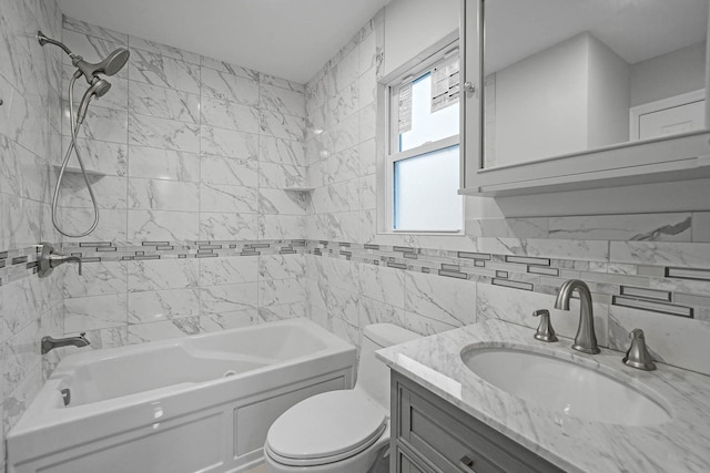 full bathroom featuring tiled shower / bath combo, vanity, tile walls, and toilet