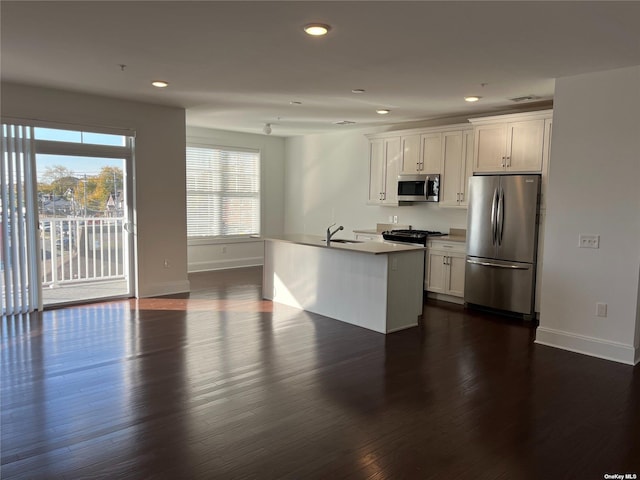 kitchen featuring appliances with stainless steel finishes, sink, a center island with sink, and white cabinets