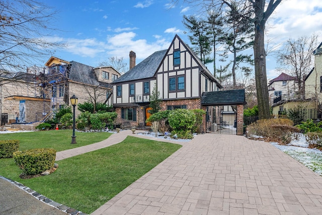 tudor-style house with a front yard