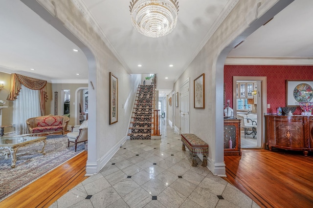 foyer with ornamental molding, a chandelier, and light wood-type flooring