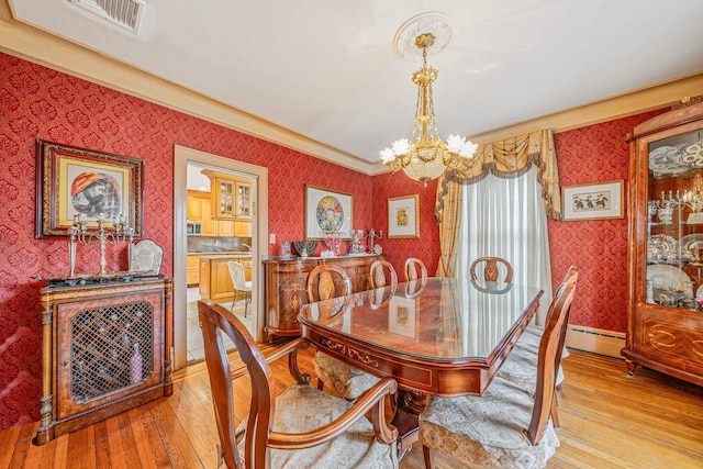 dining area featuring a chandelier, baseboard heating, and light hardwood / wood-style floors