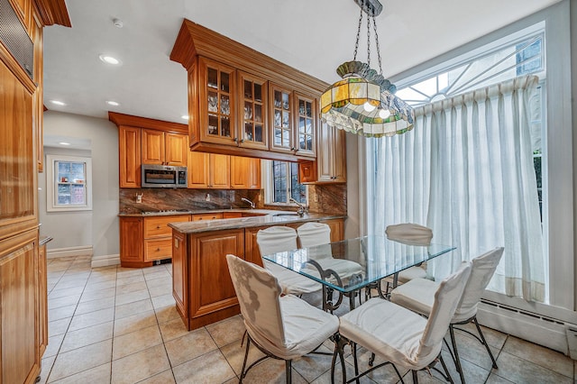 dining area featuring a baseboard radiator, sink, and light tile patterned flooring