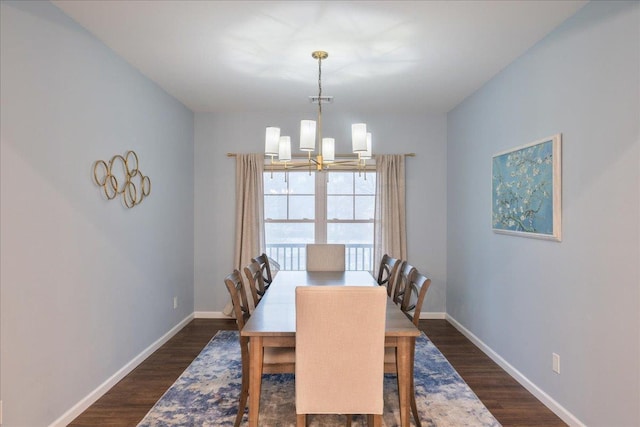 dining space with dark hardwood / wood-style flooring and an inviting chandelier