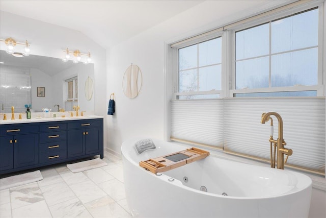 bathroom featuring vaulted ceiling, vanity, and a bathtub