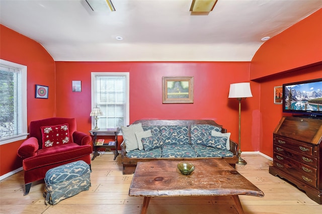 living room featuring lofted ceiling and light wood-type flooring