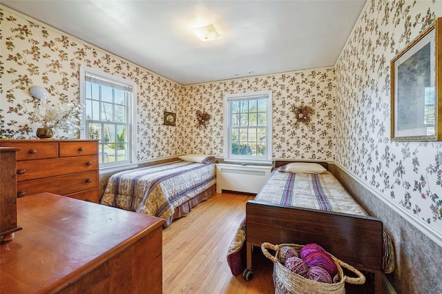 bedroom featuring multiple windows and light hardwood / wood-style flooring