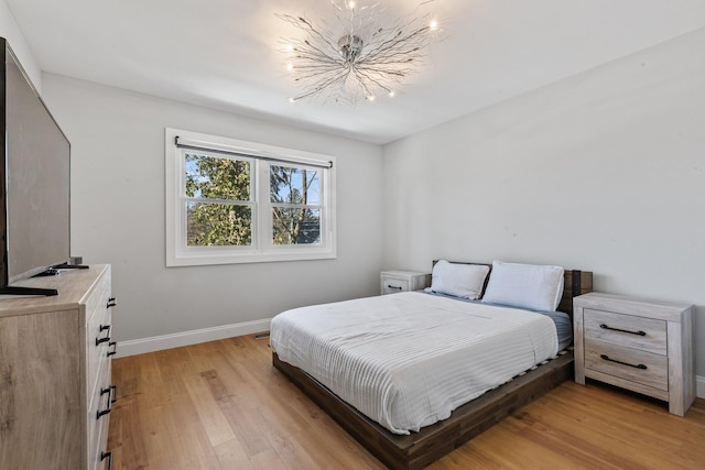 bedroom with an inviting chandelier and light hardwood / wood-style flooring