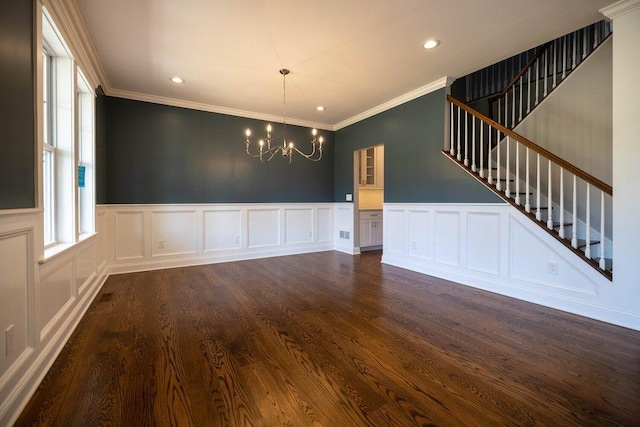 unfurnished dining area featuring an inviting chandelier, ornamental molding, and dark hardwood / wood-style floors