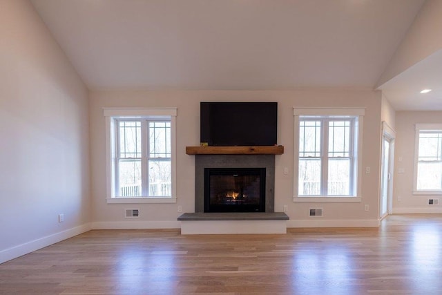 unfurnished living room featuring lofted ceiling and light wood-type flooring