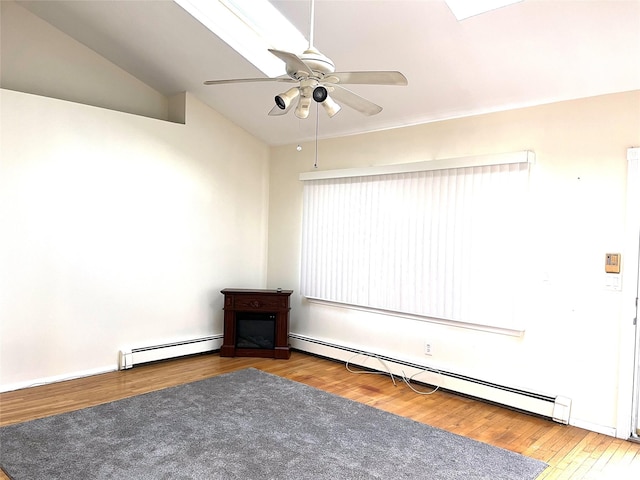 empty room with baseboard heating, ceiling fan, wood-type flooring, and lofted ceiling