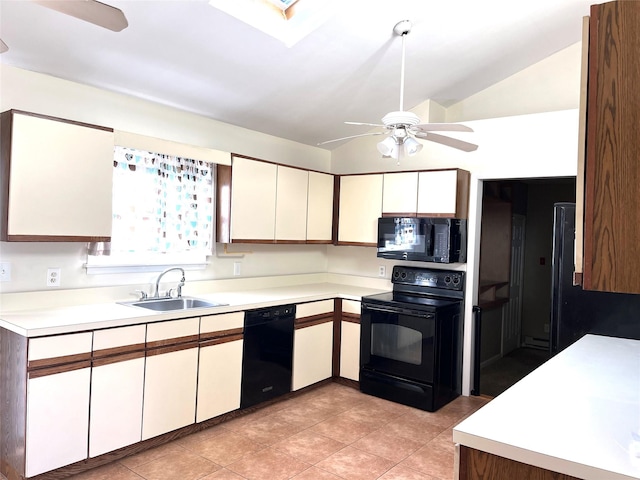 kitchen with vaulted ceiling with skylight, white cabinetry, sink, ceiling fan, and black appliances