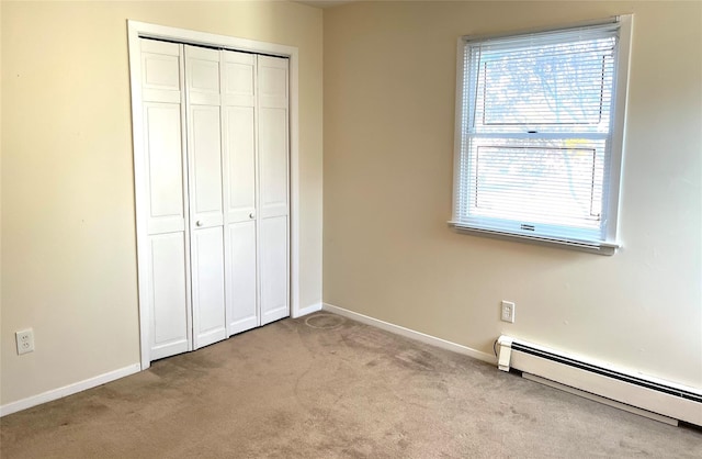 unfurnished bedroom featuring light carpet, a baseboard radiator, and a closet