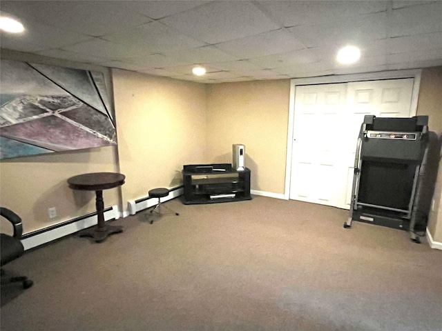 exercise room with a baseboard radiator, carpet flooring, and a drop ceiling