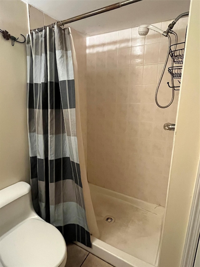 bathroom featuring tile patterned flooring, curtained shower, and toilet