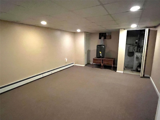 basement featuring a drop ceiling and baseboard heating