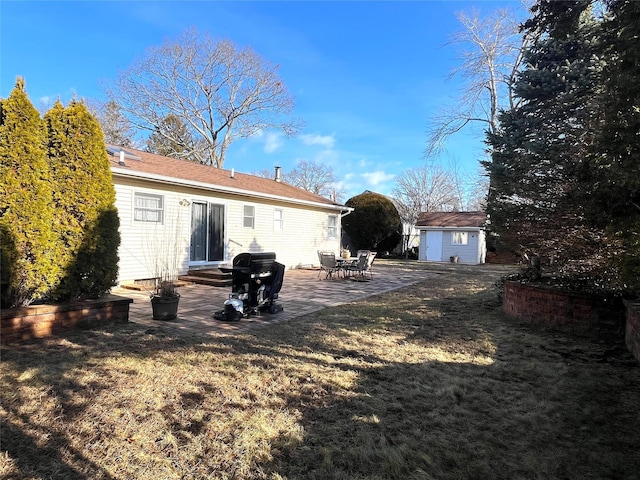 back of house featuring a yard, a patio area, and a storage unit