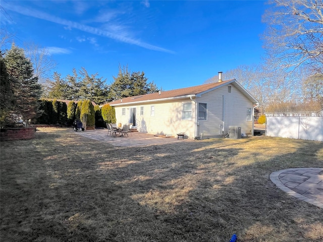 back of house featuring central AC, a patio area, and a lawn