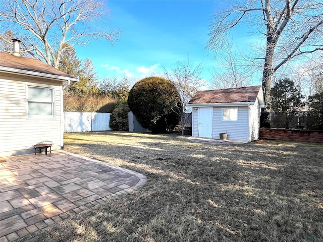 view of yard featuring an outdoor fire pit, a patio area, and a shed