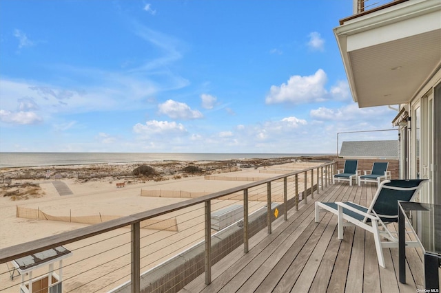 balcony featuring a water view and a beach view